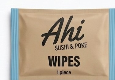 Single-piece Ahi hand wipe in a kraft wrapper with sky-blue edges